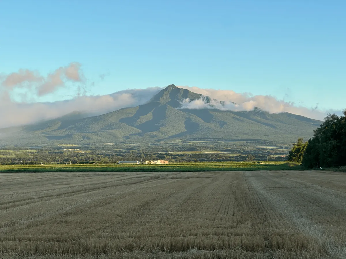Mt Shari, some fog rolling in around the top of it, illuminated by the sunrise.